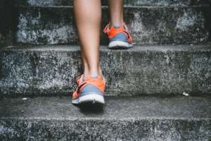 Person in running shoes walking on concrete stairs