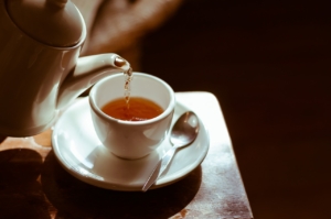 Pouring tea into a cup from a teapot